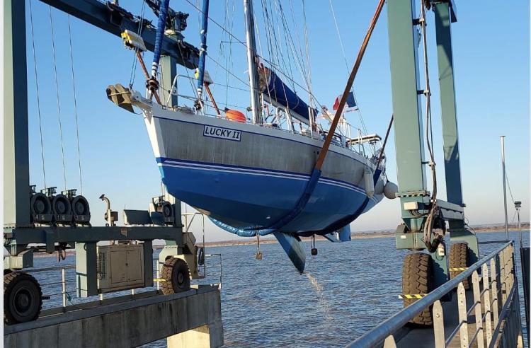 Sailboat "Lucky II" being lifted by crane, Custom Patago 40, 2019 model, at a marina.
