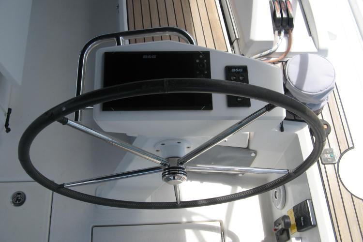 Steering wheel of a 2019 Beneteau Oceanis 46.1 yacht with navigation controls.