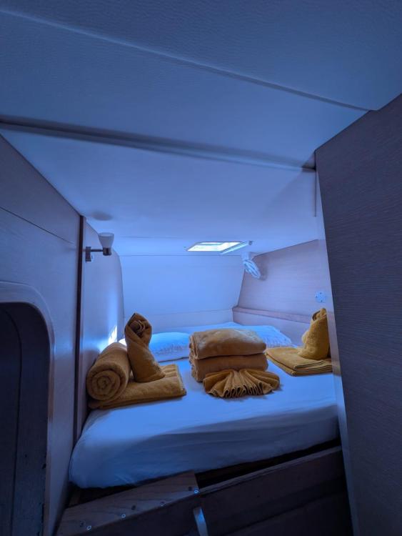 Cozy cabin interior of 2012 Catana 55 yacht with neatly arranged yellow towels.