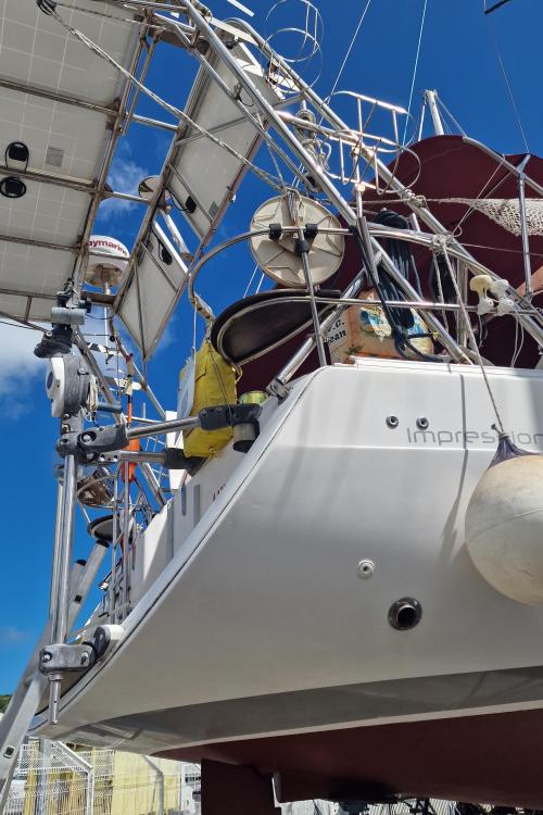 2007 Elan Impression 434 yacht with solar panels and rigging against a clear blue sky.