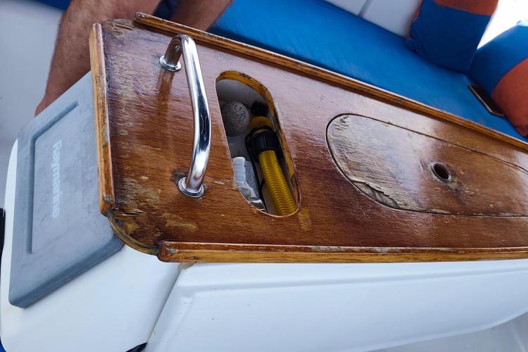 Wooden deck detail on 2005 Beneteau Cyclades 43.3 sailboat, featuring storage compartment and handle.