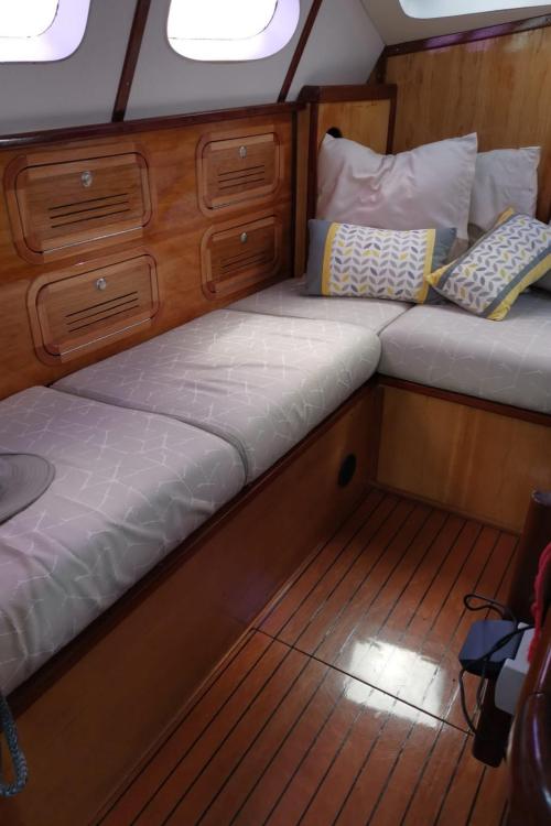Cozy cabin interior of 2019 Custom Patago 40 yacht with wooden finish and cushioned seating.
