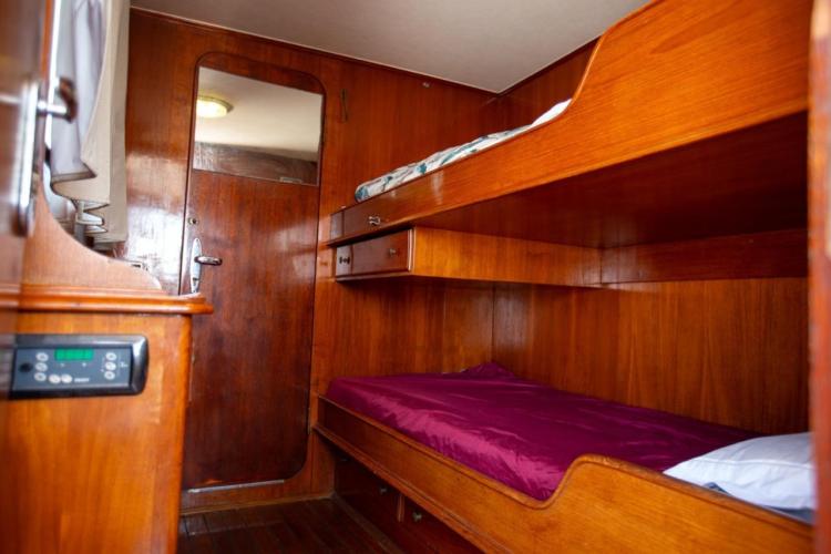 Wood-paneled cabin with bunk beds on a 1972 Benetti 33 yacht.