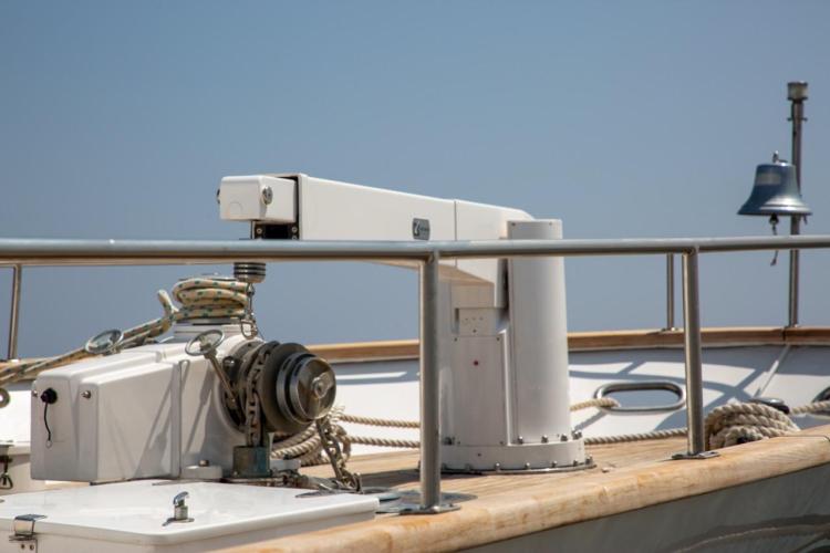 1972 Benetti 33 yacht deck with winch and bell under clear sky.