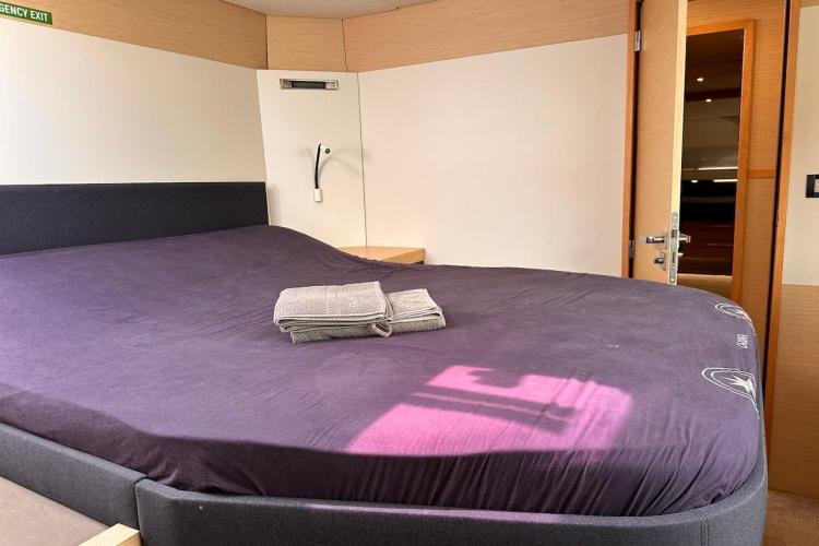 Luxurious bedroom interior of 2016 Fountaine Pajot Ipanema 58 yacht with neatly folded towels.