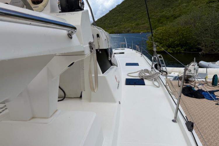 2020 Fountaine Pajot Astrea 42 catamaran docked by lush green hills and calm waters.