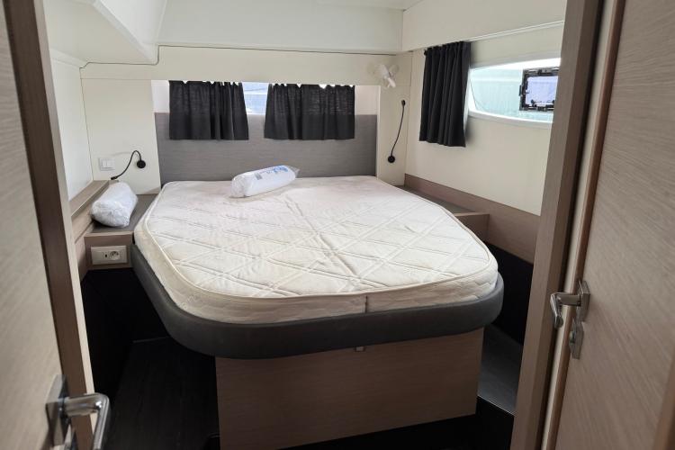 Cabin interior of 2020 Fountaine Pajot Astrea 42 catamaran with cozy bed and modern design.