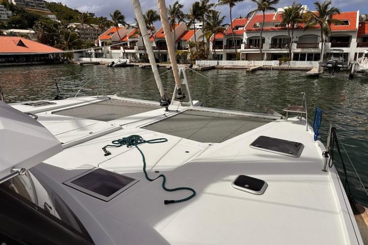 2016 Fountaine Pajot Ipanema 58 catamaran docked near waterfront homes.