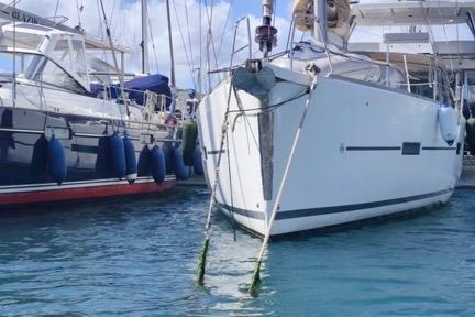 2017 Dufour 460 Grand Large yacht docked in marina, calm waters, clear sky.