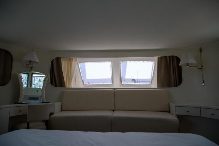 Interior of 1972 Benetti 33 yacht with elegant seating and large windows.