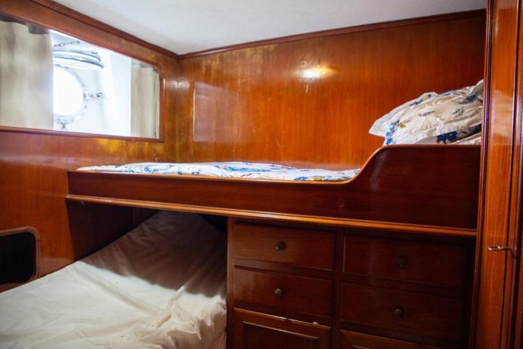 Cozy wooden cabin interior with bunk beds on a 1972 Benetti 33 yacht.