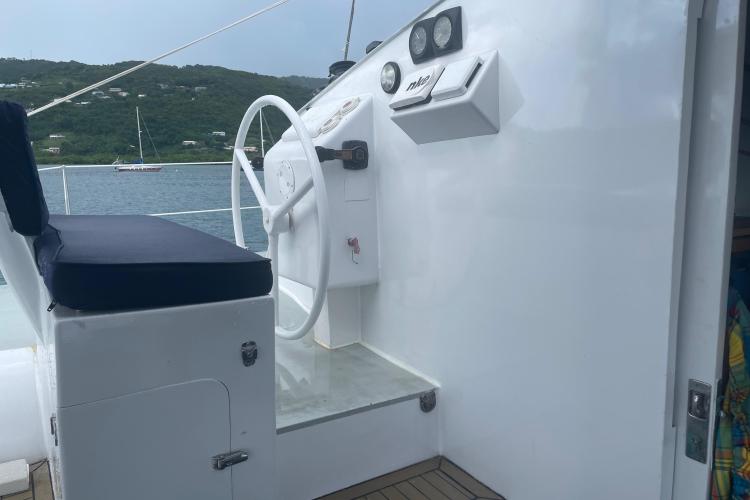 Helm of Custom KSENIA 149 yacht, featuring a white steering wheel and cushioned seat.