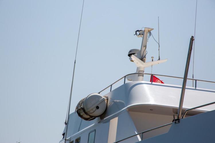 Close-up of 1972 Benetti 33 yacht deck with radar and flag.