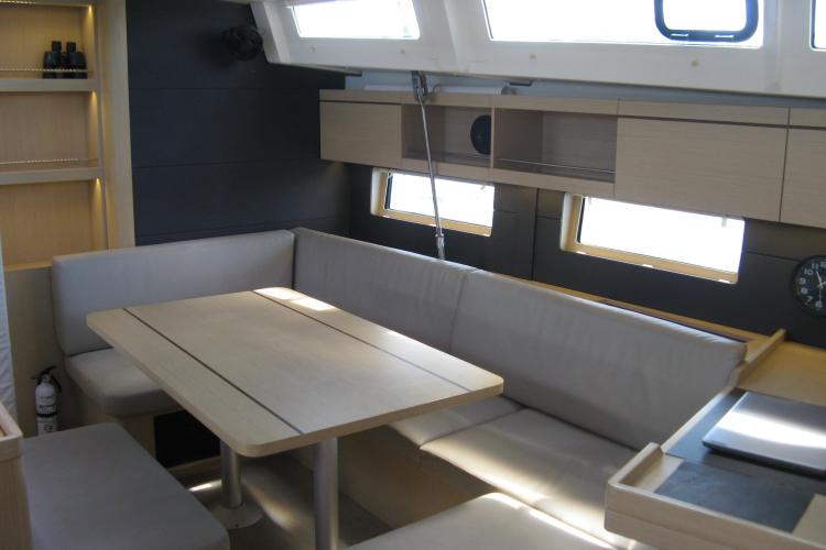 Interior of 2019 Beneteau Oceanis 46.1 yacht with modern dining area and seating.