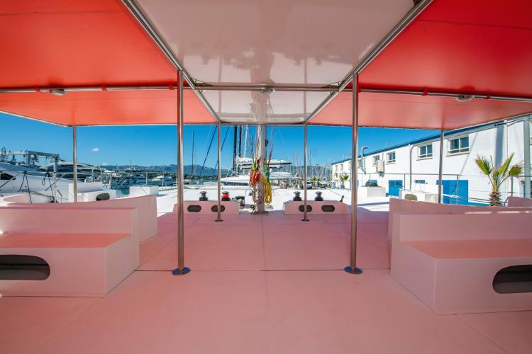 Spacious deck of 2026 Custom DAYCHARTER boat with red canopy and marina view.