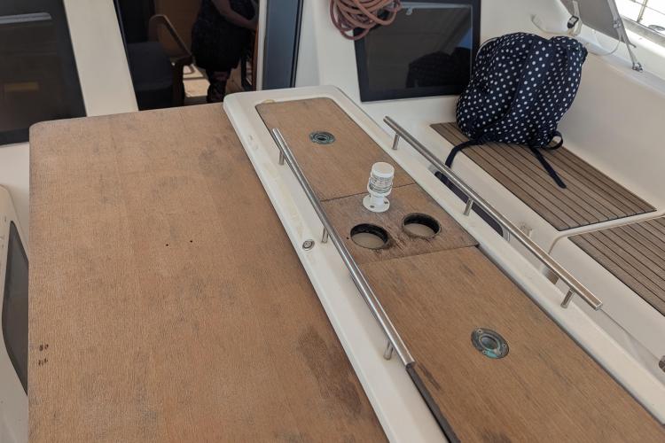 2017 Dufour 460 Grand Large yacht deck with wooden table and polka dot bag.