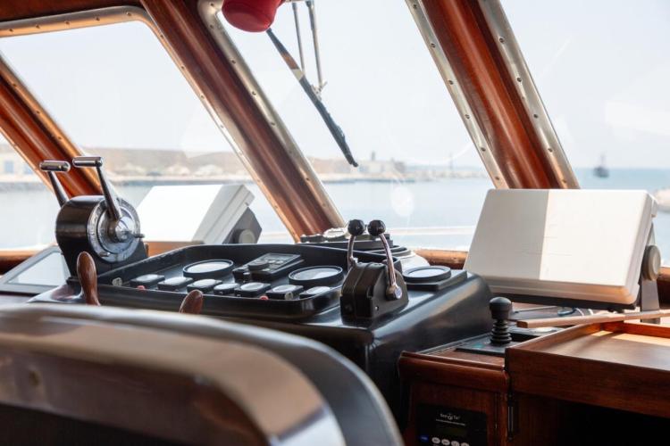 Bridge of a 1972 Benetti 33 yacht, featuring classic navigation controls and sea view.