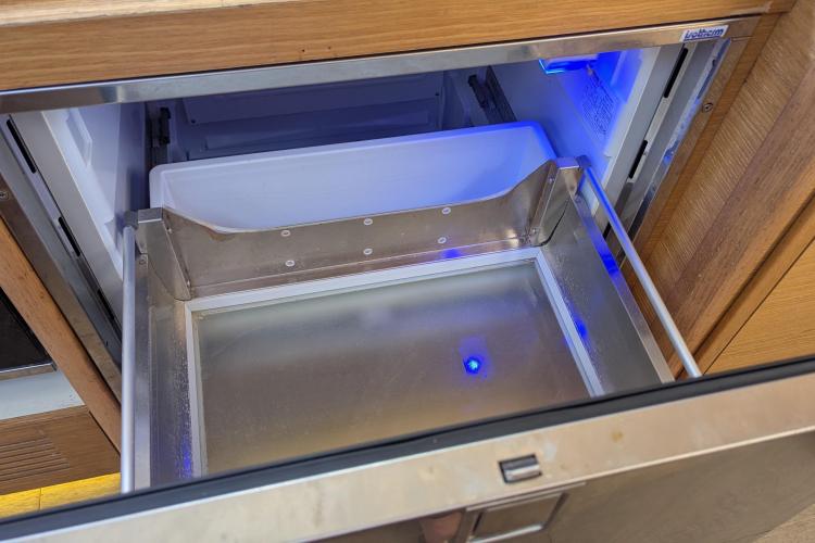 Open refrigerator drawer with blue LED light on Dufour 460 Grand Large yacht, 2017 model.