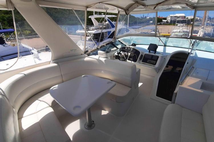 2000 Carver 530 Voyager Pilothouse interior with helm, seating, and table in marina setting.